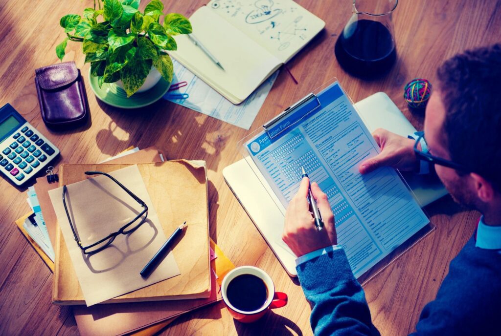 Couple signing closing documents with title commitment explained by real estate agent